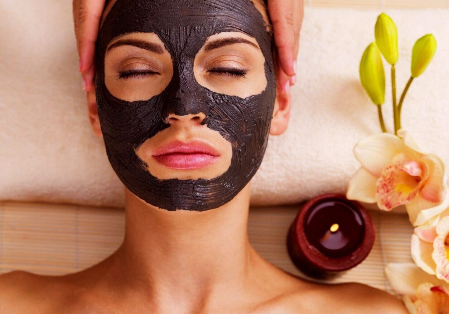 Woman with charcoal face mask at spa